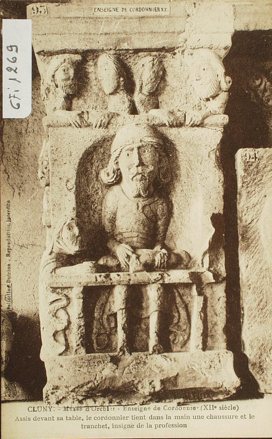 Cluny. Musée d'Ochier. Enseigne de cordonnier (XIIe s.). Assis devant sa table, le cordonnier tient dans la main une chaussure et le tranchet, insigne de la profession.