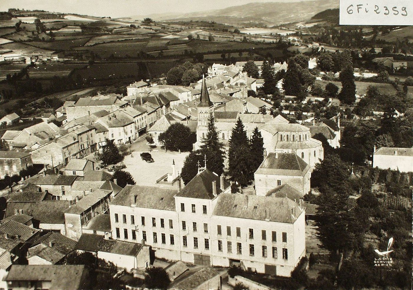 En avion au dessus-de ... Matour. Vue d'ensemble. La mairie et les écoles.
