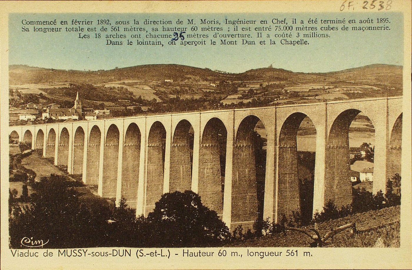 Viaduc de Mussy-sous-Dun. Hauteur 60 m, longueur 561 m. Commencé en février 1892, sous la direction de M. Moris, ingénieur en chef, il a été terminé en août 1895. Sa longueur totale est de 561 mètres, sa hauteur 60 mètres ; il est entré 75 000 mètres cubes de maçonnerie. Les 18 arches ont chacune 25 mètres d'ouverture. Il a coûté 3 millions. Dans le lointain, on aperçoit le Mont Dun et la chapelle.