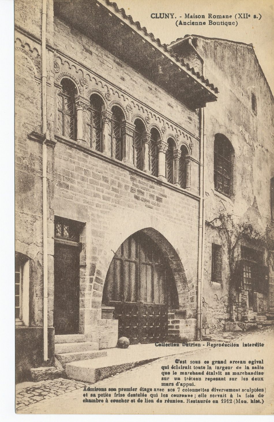 Cluny. Maison romane (XIIe s.) (ancienne boutique). C'est sous ce grand arceau ogival qui éclairait toute la largeur de la salle que le marchand étalait sa marchandise sur un tréteau reposant sur les deux murs d'appui. Admirons son premier étage avec ses 7 colonnettes diversement sculptées et sa petite frise dentelée qui les couronne ; elle servait à la fois de chambre à coucher et de lieu de réunion. Restauré en 1912. (Mon. hist).
