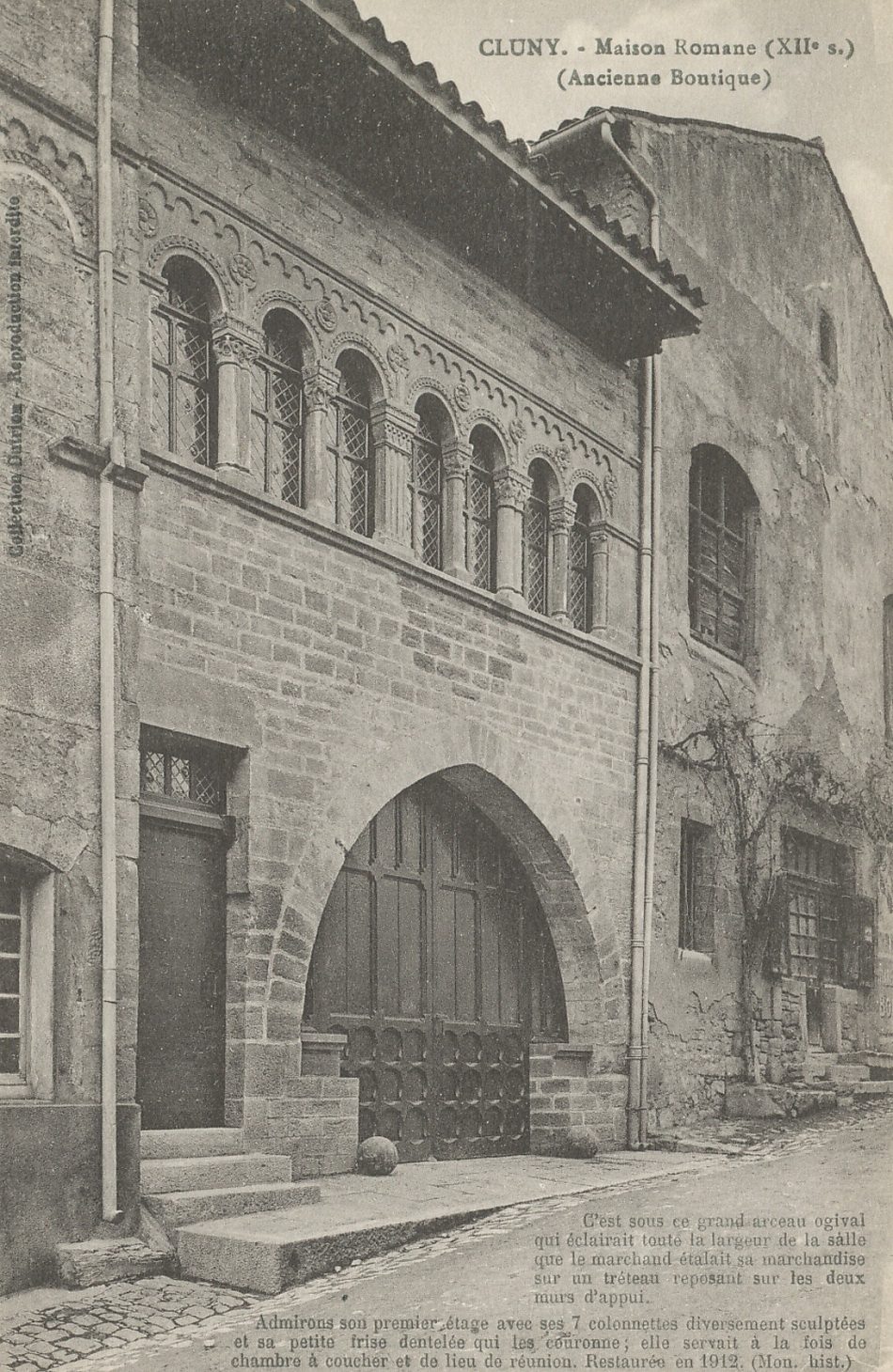 Cluny. Maison romane (XIIe s.). (Ancienne boutique). C'est sous ce grand arceau ogival qui éclairait toute la largeur de la salle que le marchand étalait sa marchandise sur un tréteau reposant sur les deux murs d'appui. Admirons son premier étage avec ses 7 colonnettes diversement sculptées et sa petite frise dentelée qui la couronne ; elle servait à la fois de chambre à coucher et de lieu de réunion. Restaurées en 1912 (Mon. hist.).