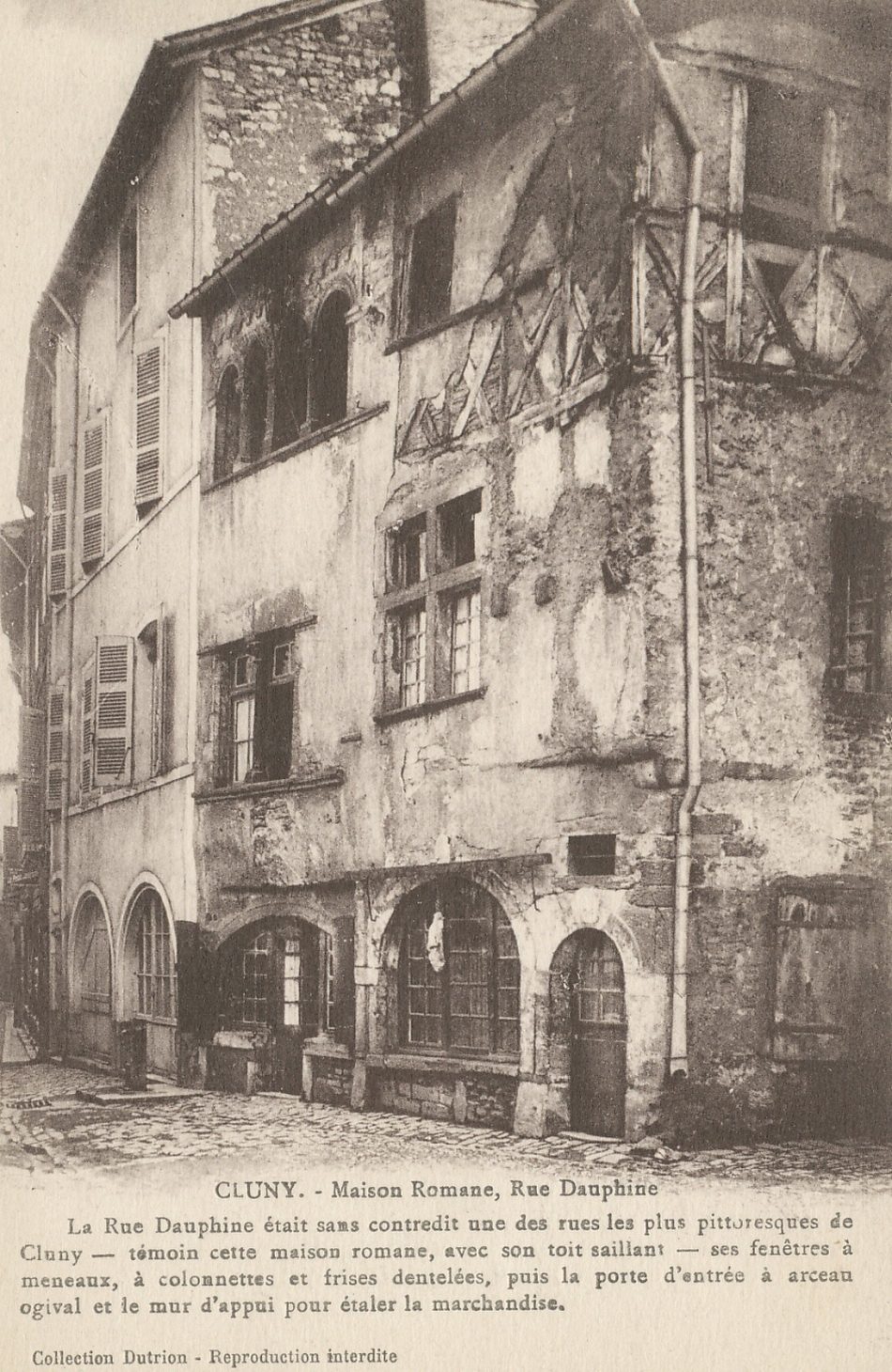Cluny. Maison romane, rue Dauphine. La rue Dauphine était sans contredit une des rues les plus pittoresques de Cluny - témoin cette maison romane, avec son toit saillant - ses fenêtres à meneaux, à colonnettes et frise dentelées, puis la porte d'entrée à arceau ogival et le mur d'appui pour étaler la marchandise.