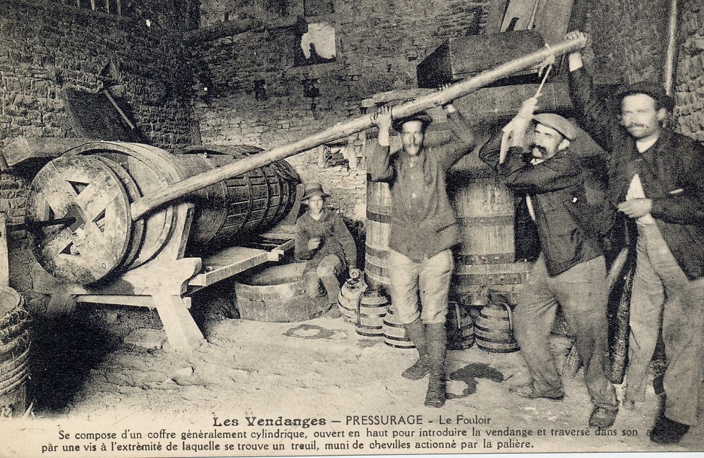 Les vendanges. Pressurage. Le fouloir. Se compose d'un coffre généralement cylindrique ouvert en haut pour introduire la vendange et traversé dans son arc par une vis à l'extrémité de laquelle se trouve un treuil, muni de chevilles actionnée par la palière.