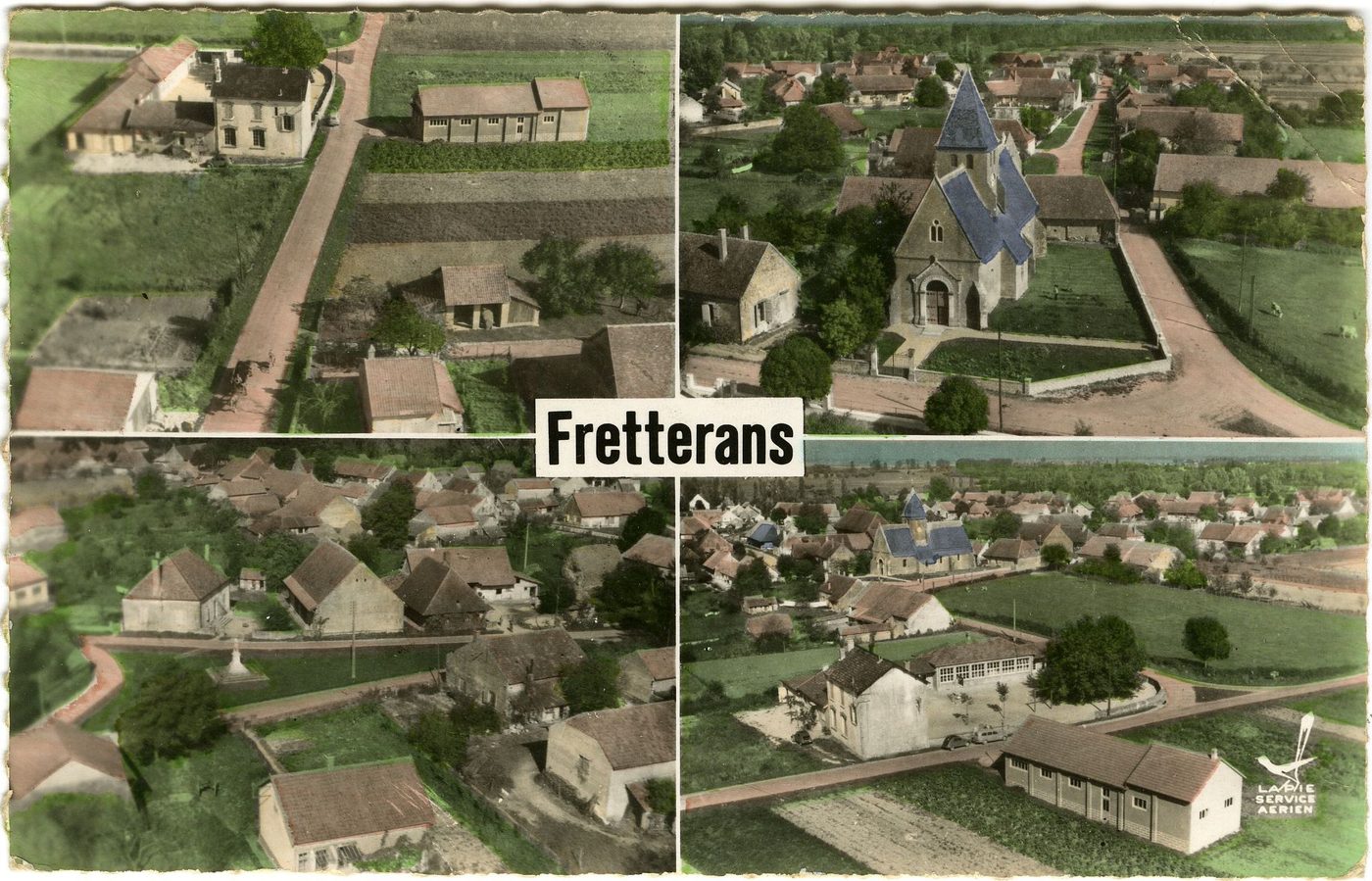 En avion au dessus de ....Fretterans. L'école, l'église, le monument, vue générale.