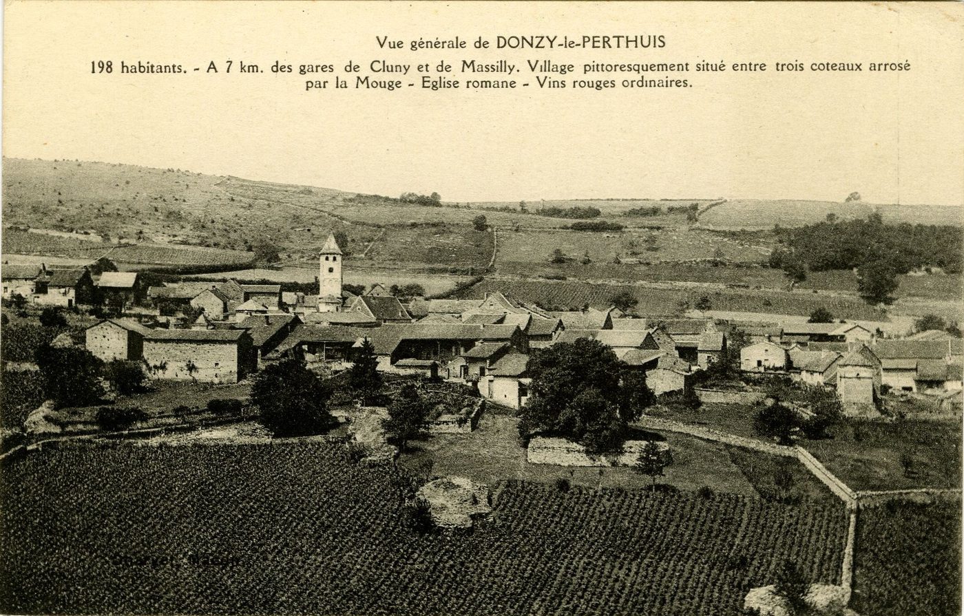 Vue générale de Donzy-le-Perthuis. 198 habitants. A 7 km des gares de Cluny et de Massilly. Village pittoresquement situé entre trois coteaux arrosé par la Mouge. Eglise romane. Vins rouges ordinaires.