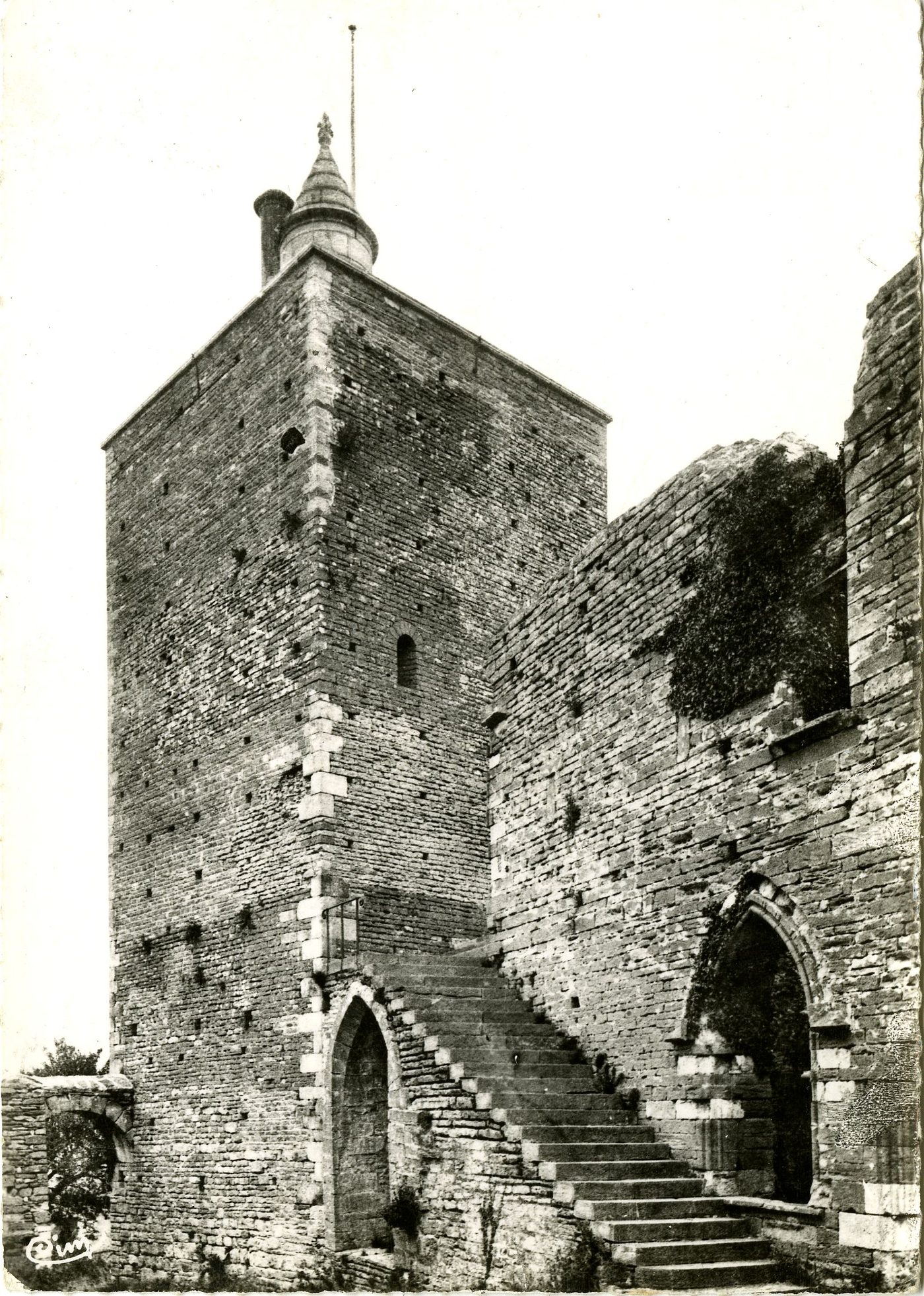 Brancion. Tour du château. Le donjon avec un actuel escalier d'accès qui n'et pas du temps était le dernier retrait du seigneur. Au XIe s. on y pénétrait par une porte étroite à hauteur du premier étage, et au moyen d'échelles volantes. L'entrée du château lui-même est la porte en plein cintre au travers de laquelle on aperçoit le chevet de l'église de Brancion.